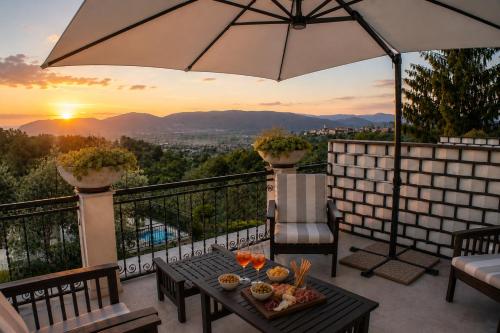 a patio with an umbrella and a table with food at Fattoria Cristina Family Duplex with Pool, Panoramic Terrace & Farm Animals - Bilo Rosa in Castelnuovo Magra