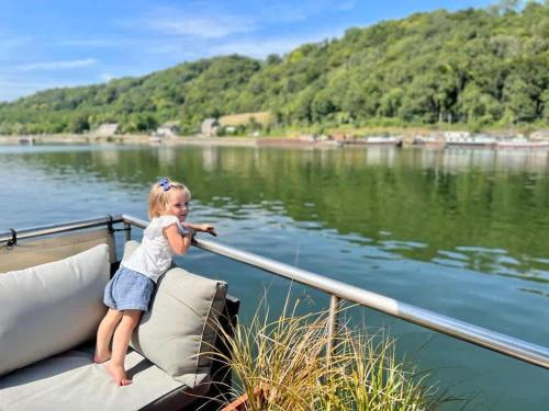 a little girl sitting on a boat on the water at Peniche a Namur - Perle rare - 8 pers in Namur