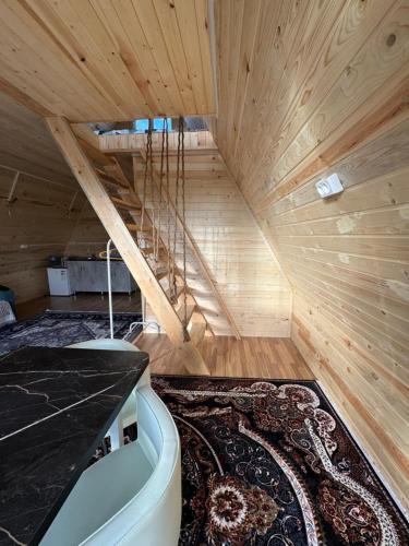 an attic room with a staircase and a rug at D&N Karakol in Karakol