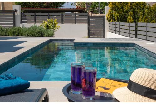 a pair of glasses sitting on a table next to a swimming pool at Exis Seaview in Vathí