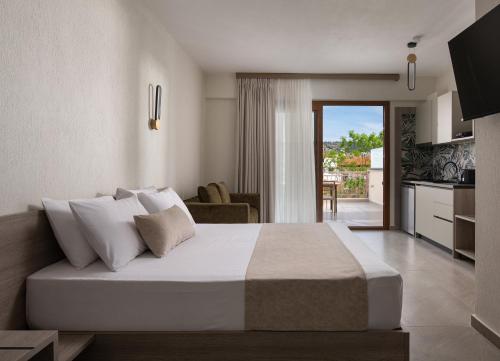 a bedroom with a large bed and a kitchen at KLG Studios and Apartment in Nikiti