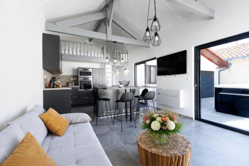 a living room and kitchen with a couch and a table at Cozy Cottage with Spa - Welkeys in Moliets-et-Maa