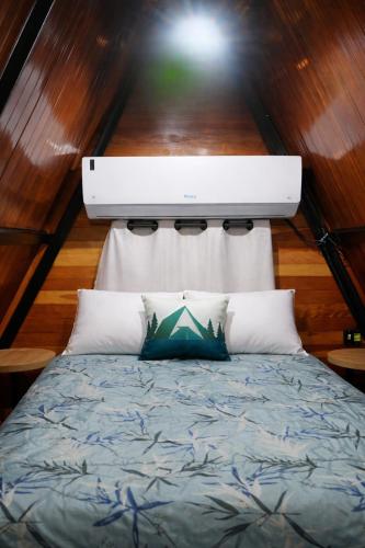 a bedroom with a bed with a light above it at Cabanas Terra Nova in Três Coroas