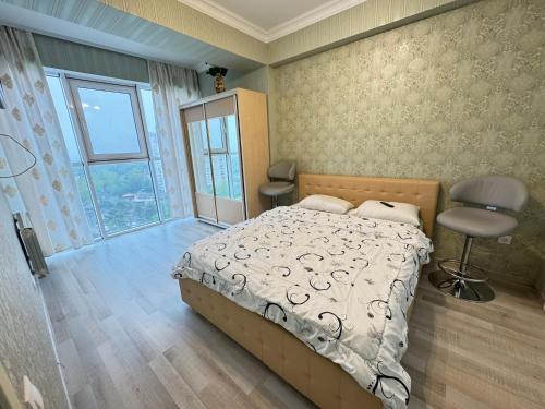 a bedroom with a bed and a chair and a window at RentDay Botanica in Chişinău