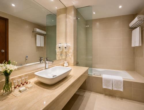 a bathroom with a sink and a bath tub at Fun & Sun Naama Waves in Sharm El Sheikh