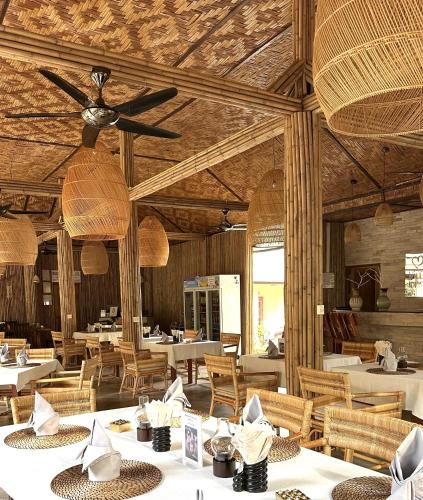 a restaurant with tables and chairs and a ceiling at Röstiland by NOXAMA SAMUI in Lamai