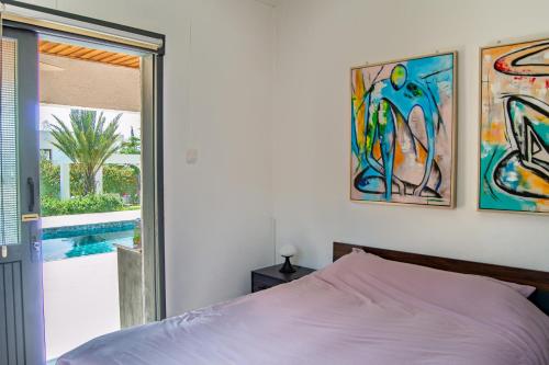 a bedroom with a bed and a view of a pool at Villa Leda - The Guest Wing in Paphos