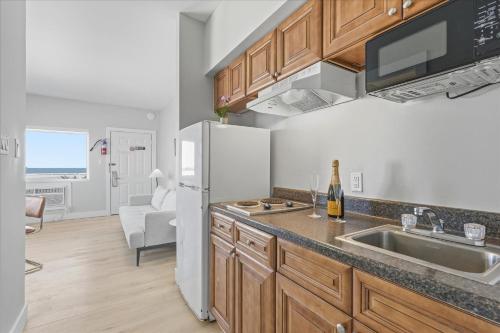 a kitchen with a white refrigerator and a sink at Coliseum Ocean Resort in Wildwood Crest