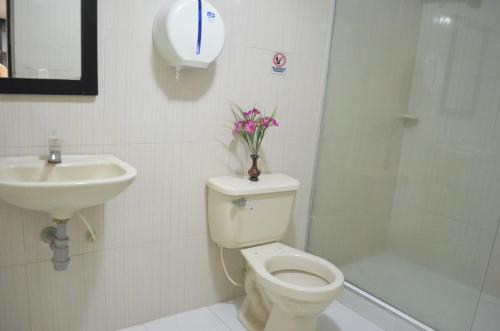 a bathroom with a toilet and a sink and a shower at Hotel San Marcos Barranquilla in Barranquilla