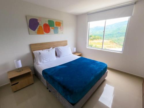 a bedroom with a large bed and a window at Apartamentos Quedate en Anavi San Gil Plaza in San Gil