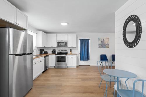 a kitchen with white cabinets and a blue table and chairs at Mins to Downtown Chic & Modern - Elegant in Noir in Chattanooga