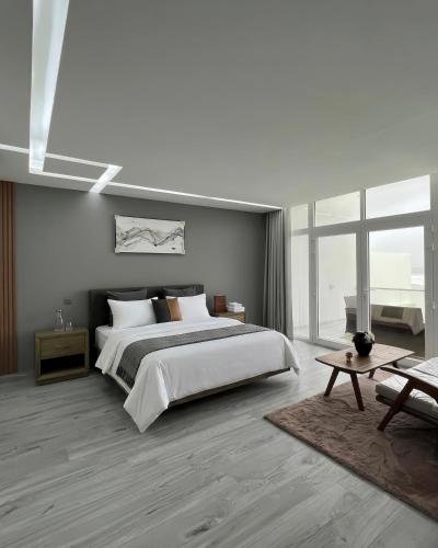 a bedroom with a large bed and a large window at bh villa in Al Sharqiyah