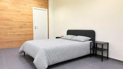 a bedroom with a bed and a white wall at Orléan 41 A centre-gare-aéroport in Charleroi