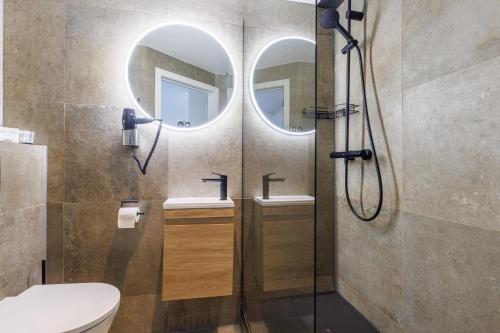 a bathroom with two sinks and a shower with two mirrors at The Black Swan Hotel in Bruges