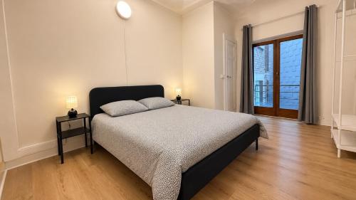 a bedroom with a bed and a large window at Orléan 41 B centre-gare-aéroport in Charleroi