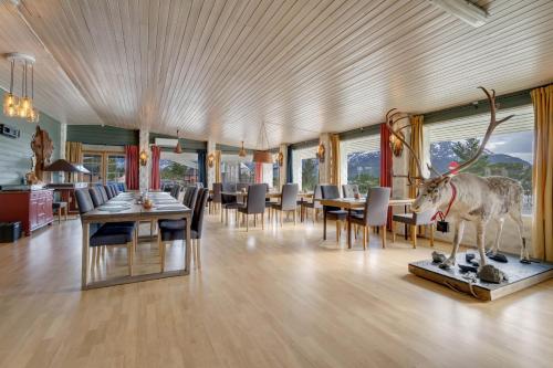 a dining room with a statue of a deer on a table at Lyngenfjord Hotel in Skibotn