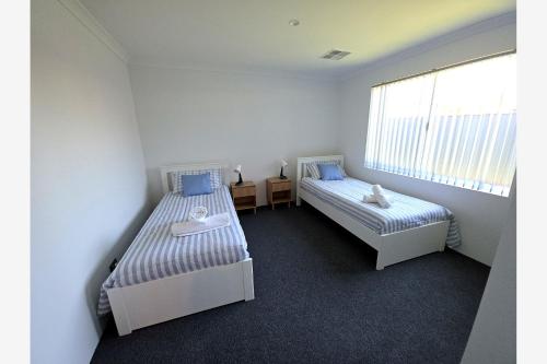 a bedroom with two beds and a window at Baldivis Retreat in Baldivis