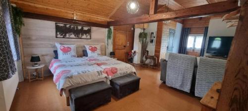a bedroom with a bed with two chairs and a television at Maison d'hôtes - Relais De La Poste in Gerbépal