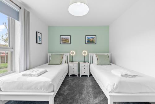 two beds in a room with two windows at Castle View in Stirling