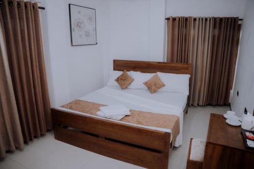 a bedroom with a bed with white sheets and pillows at Blue9 Hotel in Jaffna