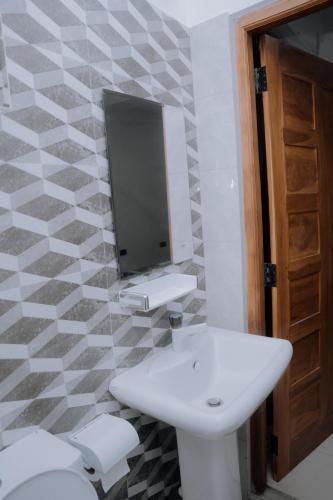 a bathroom with a sink and a tv on the wall at Blue9 Hotel in Jaffna
