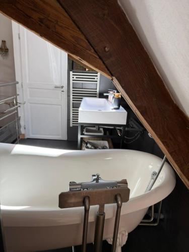 a white bath tub in a bathroom with a sink at La Cour de Lise in Willgottheim