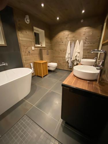 a bathroom with a tub and a sink and a toilet at Spacious Hemsedal villa with mountain views in Hemsedal