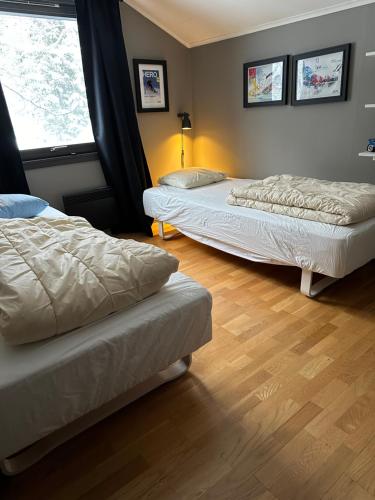 two beds in a room with a wooden floor at Spacious Hemsedal villa with mountain views in Hemsedal