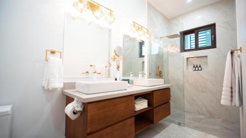 a bathroom with two sinks and a mirror and a shower at Acqua di Mare Resort in West Bay