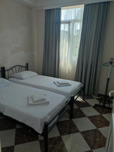 two beds in a room with a window at ოცნების სახლი Dream house in Chakvi