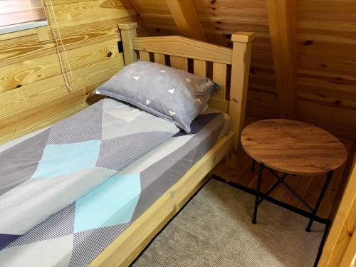 a small bed in a wooden room with a table at Masha in Žabljak