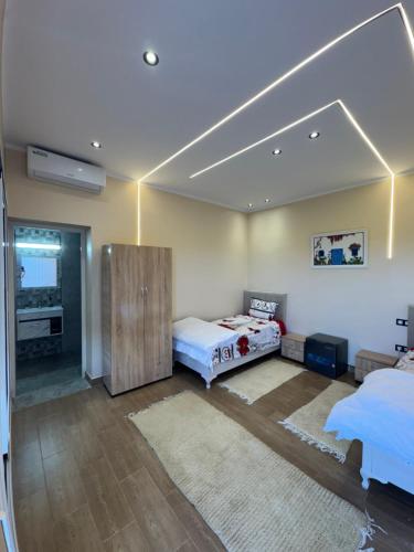 a large room with two beds and a tv at Dar Hedia in Nabeul