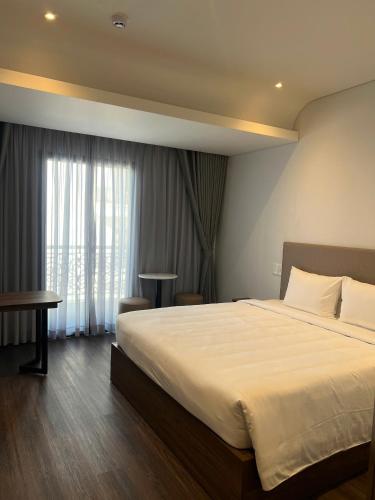 a bedroom with a large bed and a window at Ngoc Dang Anh Hotel in Nhơn Trạch