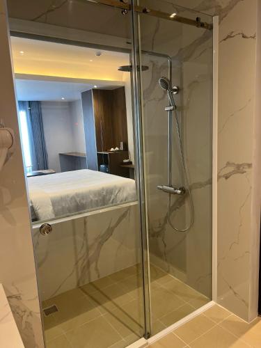 a bathroom with a glass shower with a bed at Ngoc Dang Anh Hotel in Nhơn Trạch