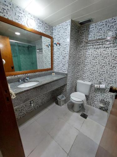 a bathroom with a toilet and a sink and a mirror at GoldMen Business Manaus - Taj Mahal in Manaus