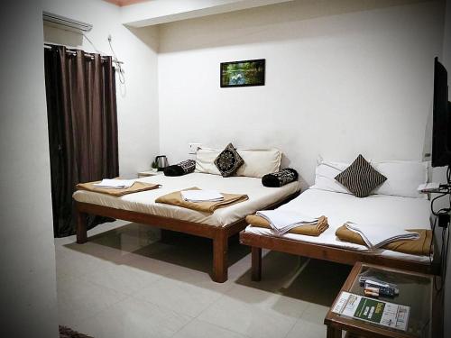 a room with two beds in a room at Green Didis Cottage in Nagaon