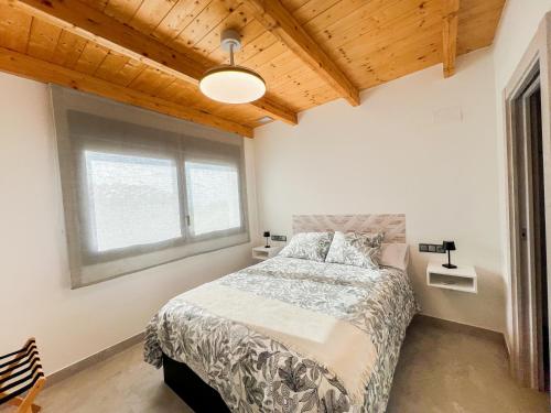 a bedroom with a bed and a large window at Apartamentos llerda in Cretas