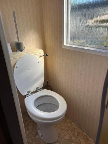 a bathroom with a white toilet with a window at Beach Resort Kamperland - 1123 in Kamperland