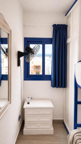 a bedroom with a white dresser and a window at Riva Eco Guest House in Los Abrigos