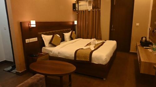 a hotel room with a bed with a towel on it at Hotel Red Sapphire Kushinagar in Kushinagar