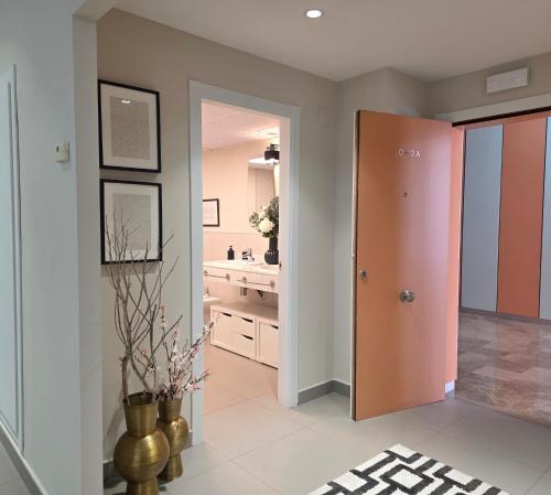 a bathroom with a hallway with a sink and a door at MD Valterna Suites & Pool in Paterna