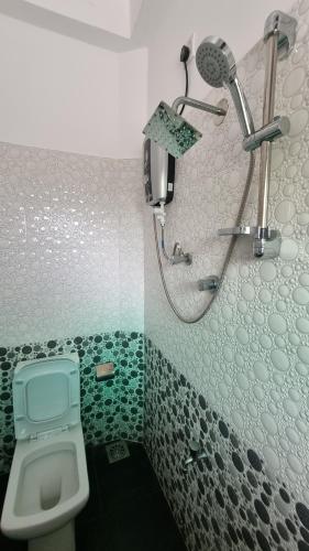 a bathroom with a shower and a toilet at Polhena Neptune Resort in Matara