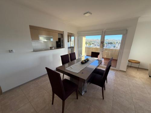 a kitchen and dining room with a table and chairs at LuxApart in Caleta Olivia