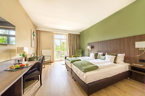 a hotel room with a large bed and a desk at relexa hotel Bad Steben in Bad Steben