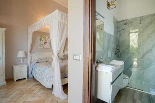 a bedroom with a bed and a shower and a bathroom at Giardini Malaspina in Bosa