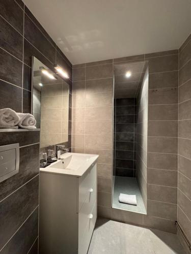 a bathroom with a sink and a shower at Hôtel des Lys in Châtillon-sur-Chalaronne