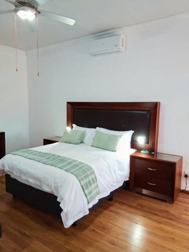 a bedroom with a bed with a green and white blanket at 30 on Latham Guesthouse in Klerksdorp