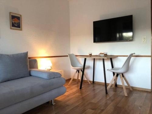 a living room with a couch and a table with chairs at Modernes Appartement - ruhig, zentrumsnah, abendsonnige Loggia in Bad Füssing