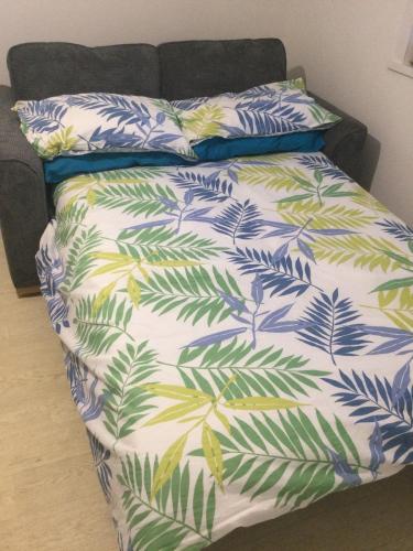 a bed with a blanket with leaves on it at Accommodation by the sea on Sanday in Orkney