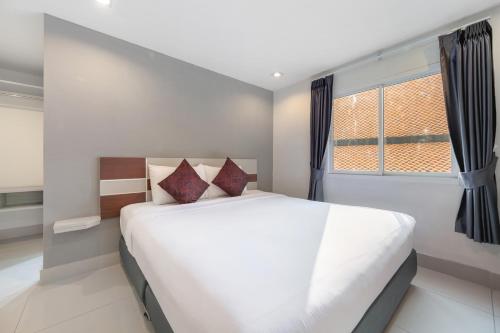 a bedroom with a large white bed and a window at V Style Pattaya North Beach in Pattaya